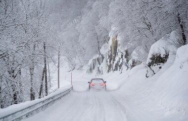 Bil på veg i vinterlandskap