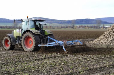 A tractor with a plough, ploughing the soil after the 2010 beet harvest, Northern Germany