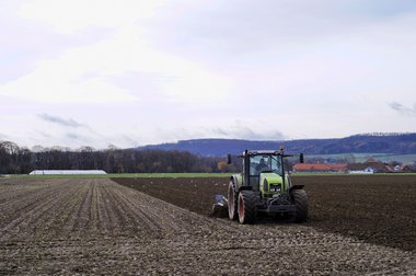 A tractor with a plough, ploughing the soil after the 2010 beet harvest, Northern Germany