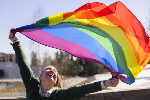 Hilde Åstrøm med et stort regnbueflagg 
