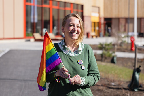 Hilde Åstrøm med regnbueflagg foran Ravinen