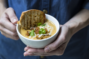 Gresskarsuppe med brødkrutonger og ristet brødskive - håndholdt