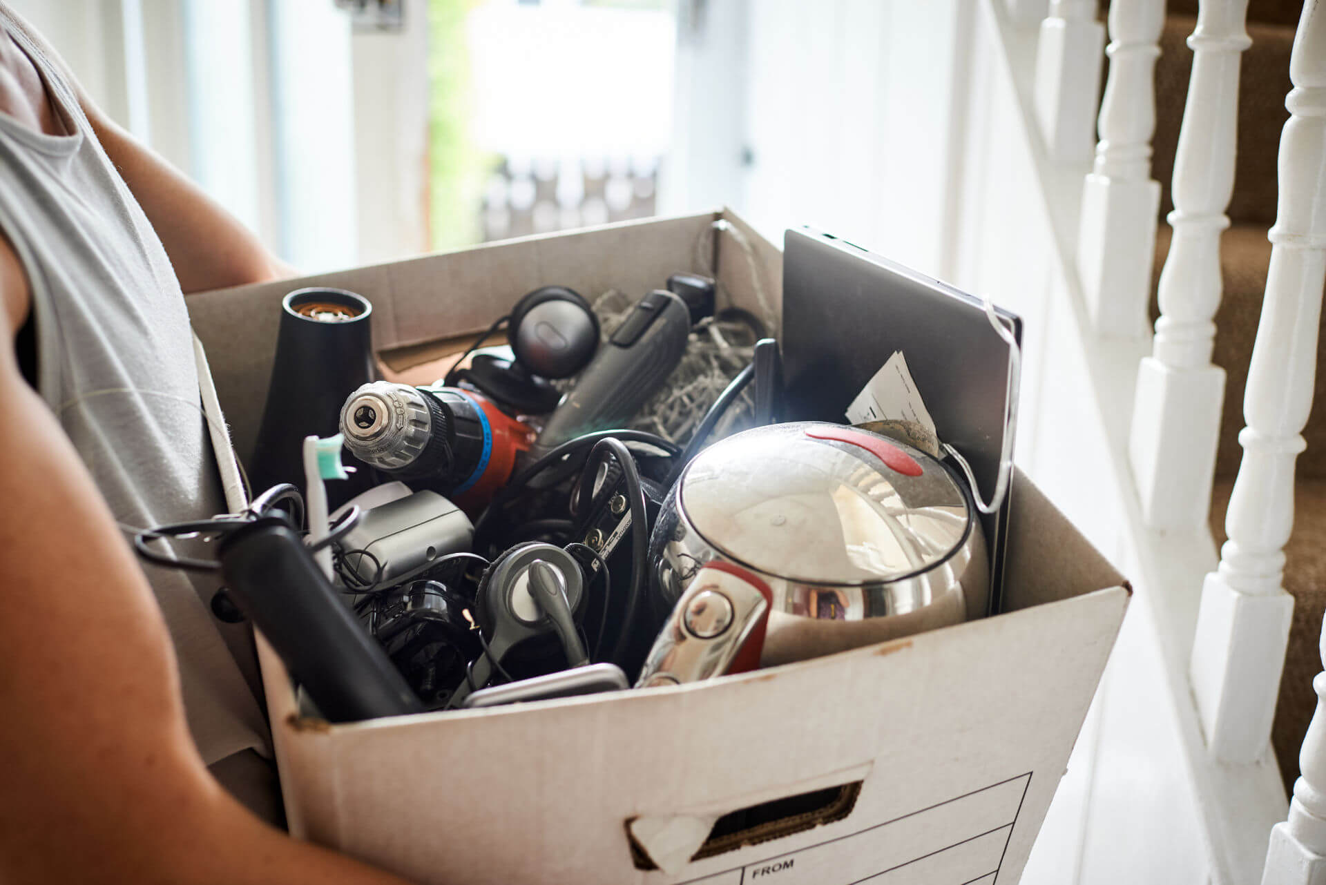 Woman holding box of electricals