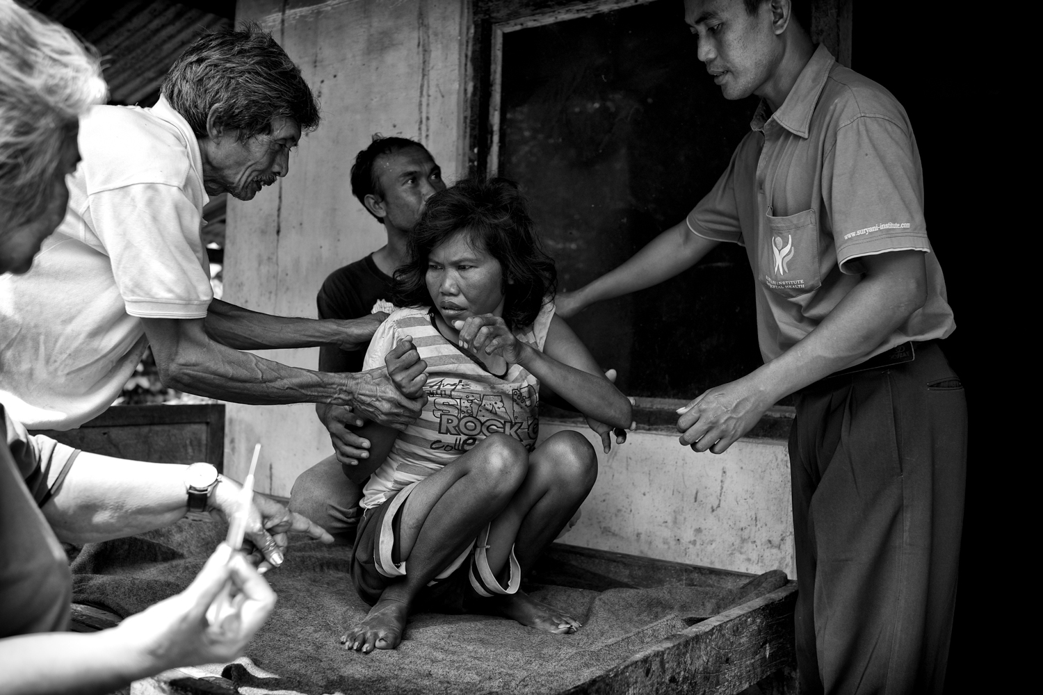 Ni Wayan a été enchaînée et enfermée dans un poulailler pendant de nombreuses années. Elle est aujourd'hui soignée par la doctoresse Suryani (à gauche sur la photo), mais n'est pas capable de communiquer et se déplace avec difficultés.