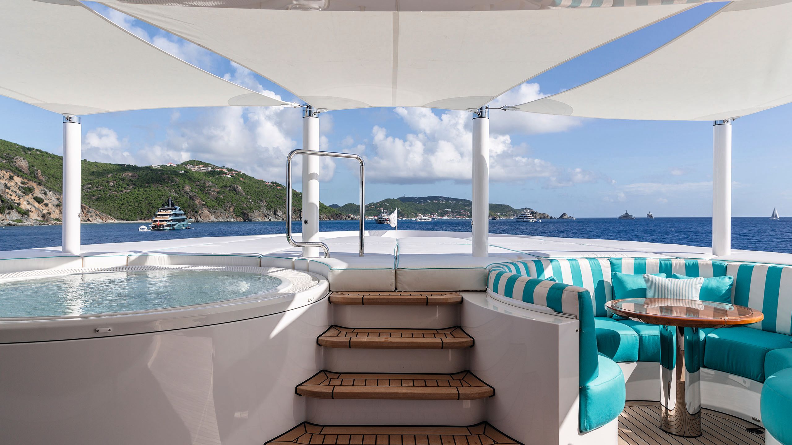 Spa pool to the left and round banquette seating to the right in a striped turquoise and white fabric