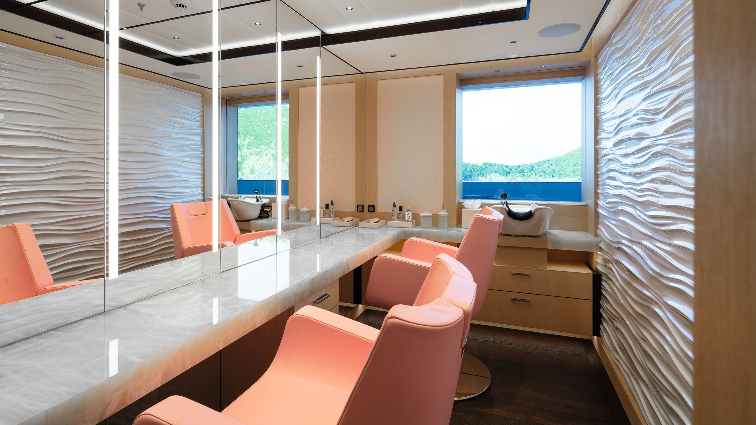 The on-deck beauty salon has a long mirror down one side, a backwash at the back and two orange salon chairs