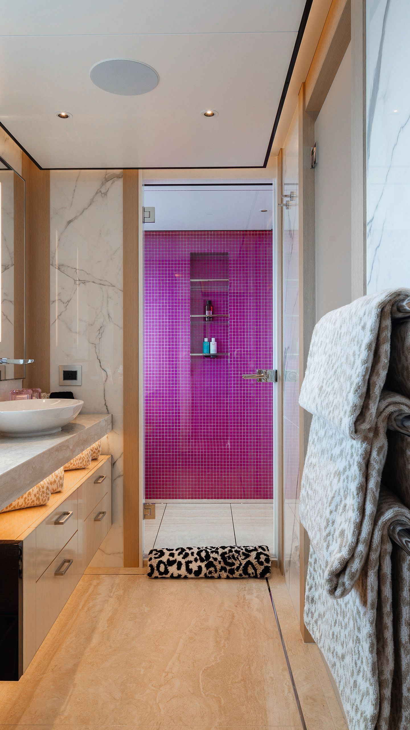 Looking down the bathroom into the shower which is tiled in bright pink