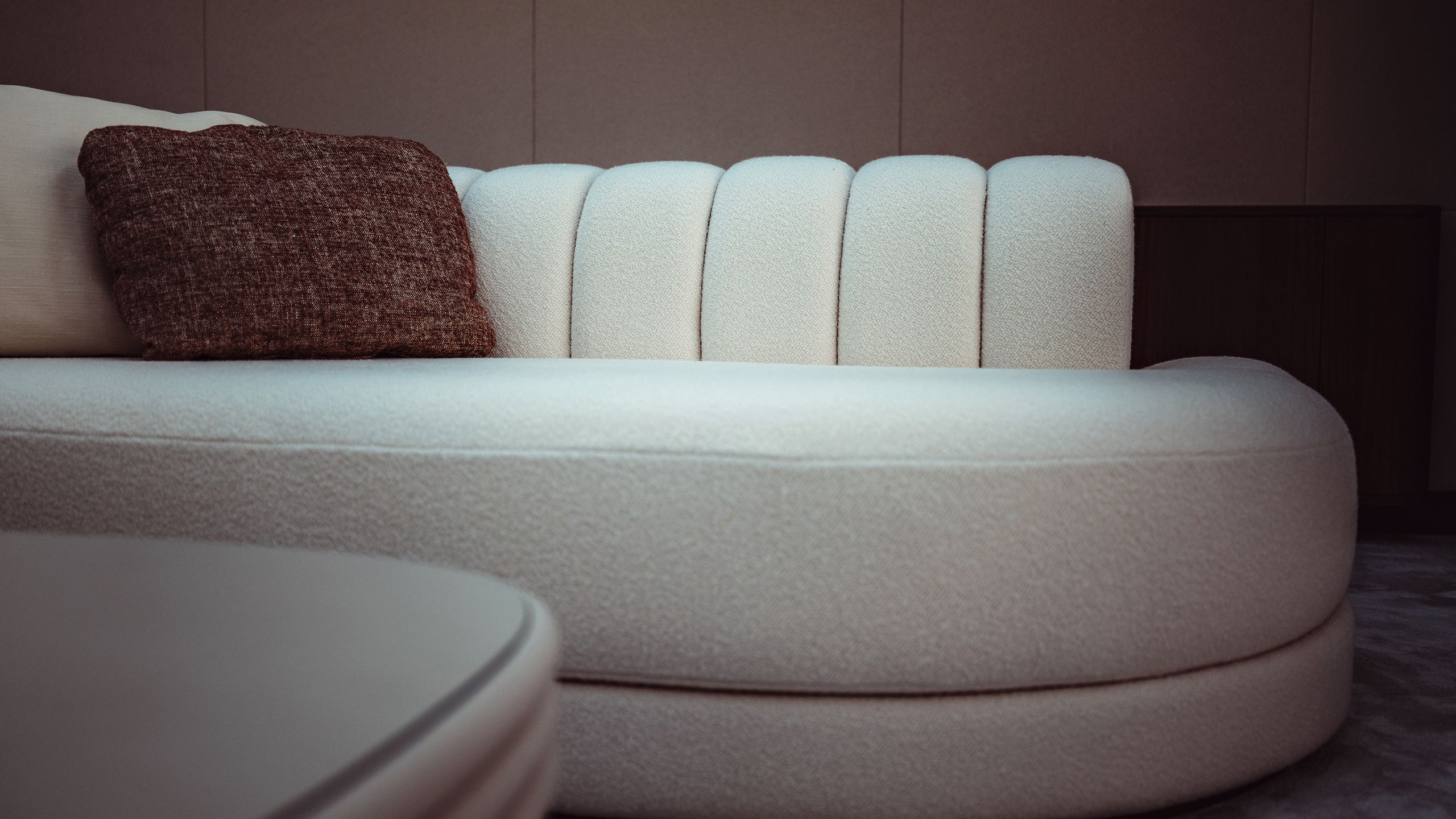 Boucle sofa in cream with brown cushion