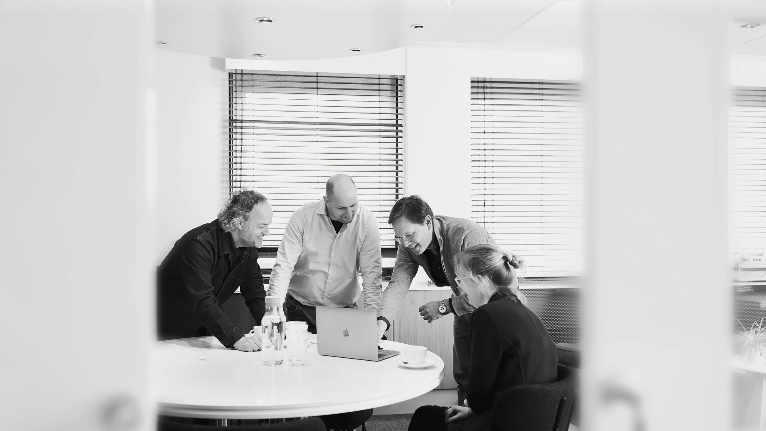 The project group huddled around a Macbook