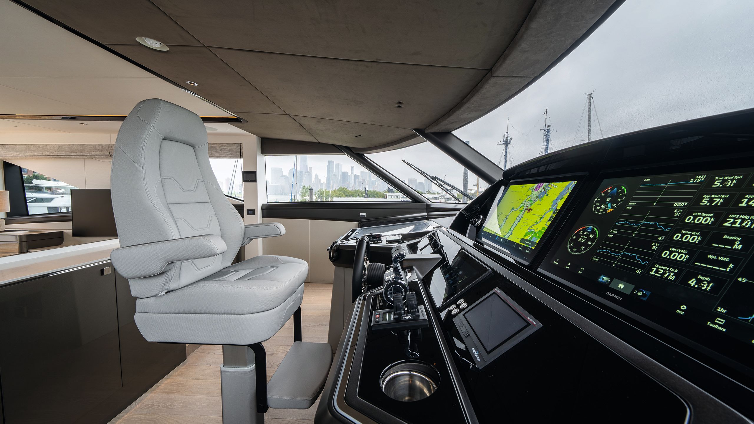 Large grey leather seat facing bank of controls and monitors