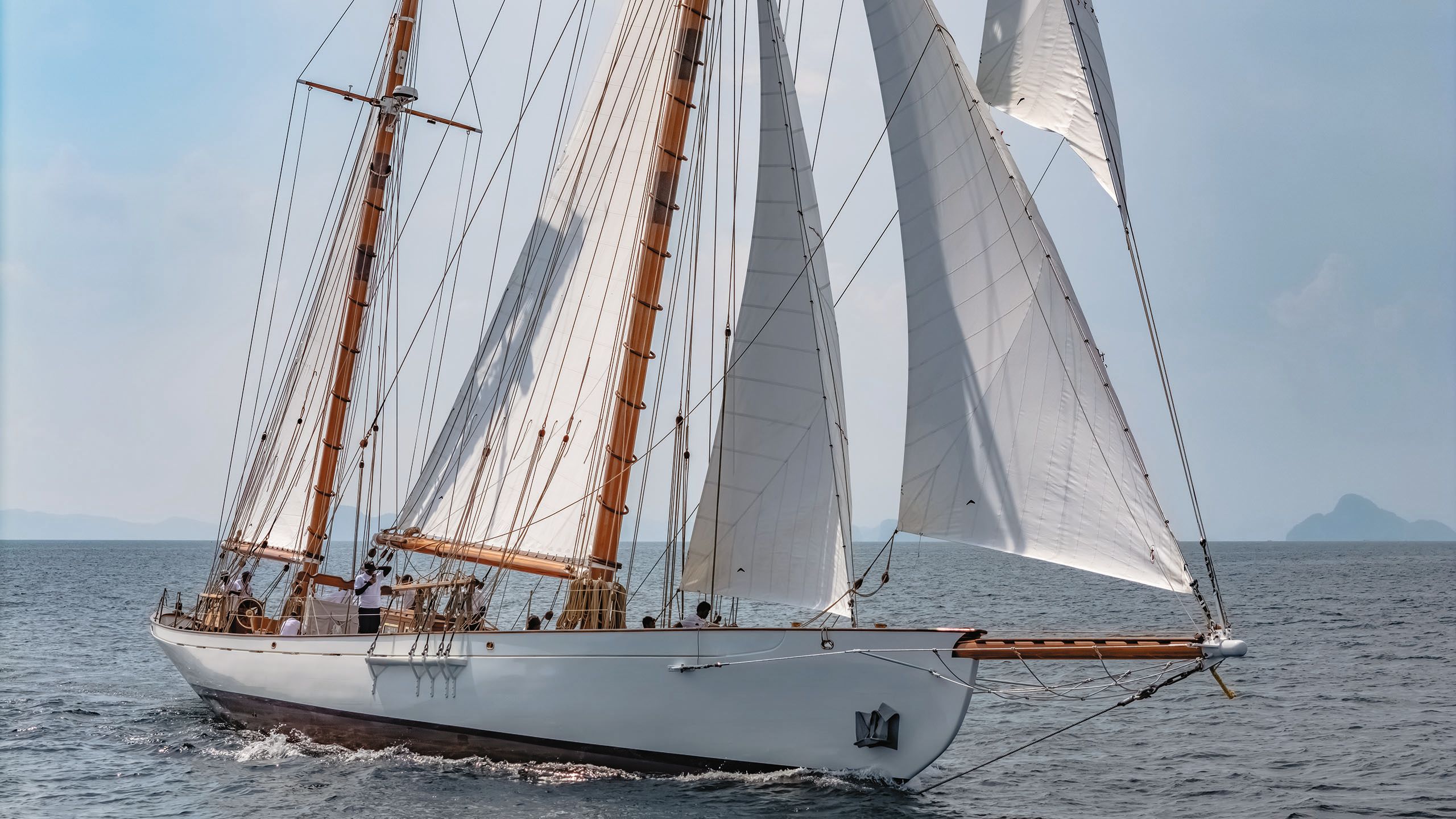 Cariad from the side with its sails out on the water