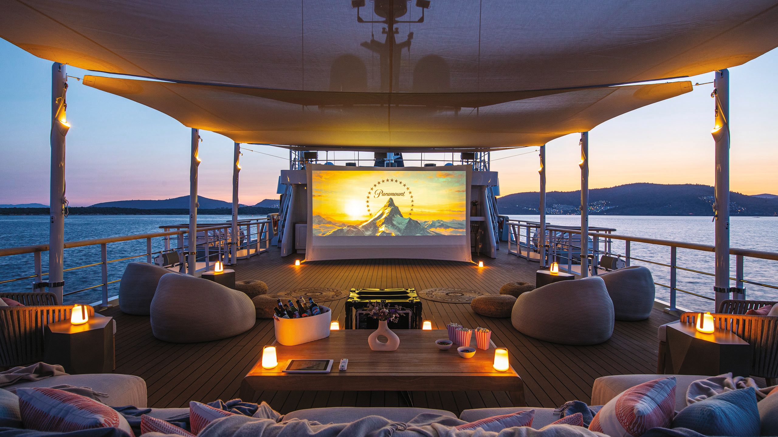 The deck after the refit with sofas, chairs, a cinema screen and lamps