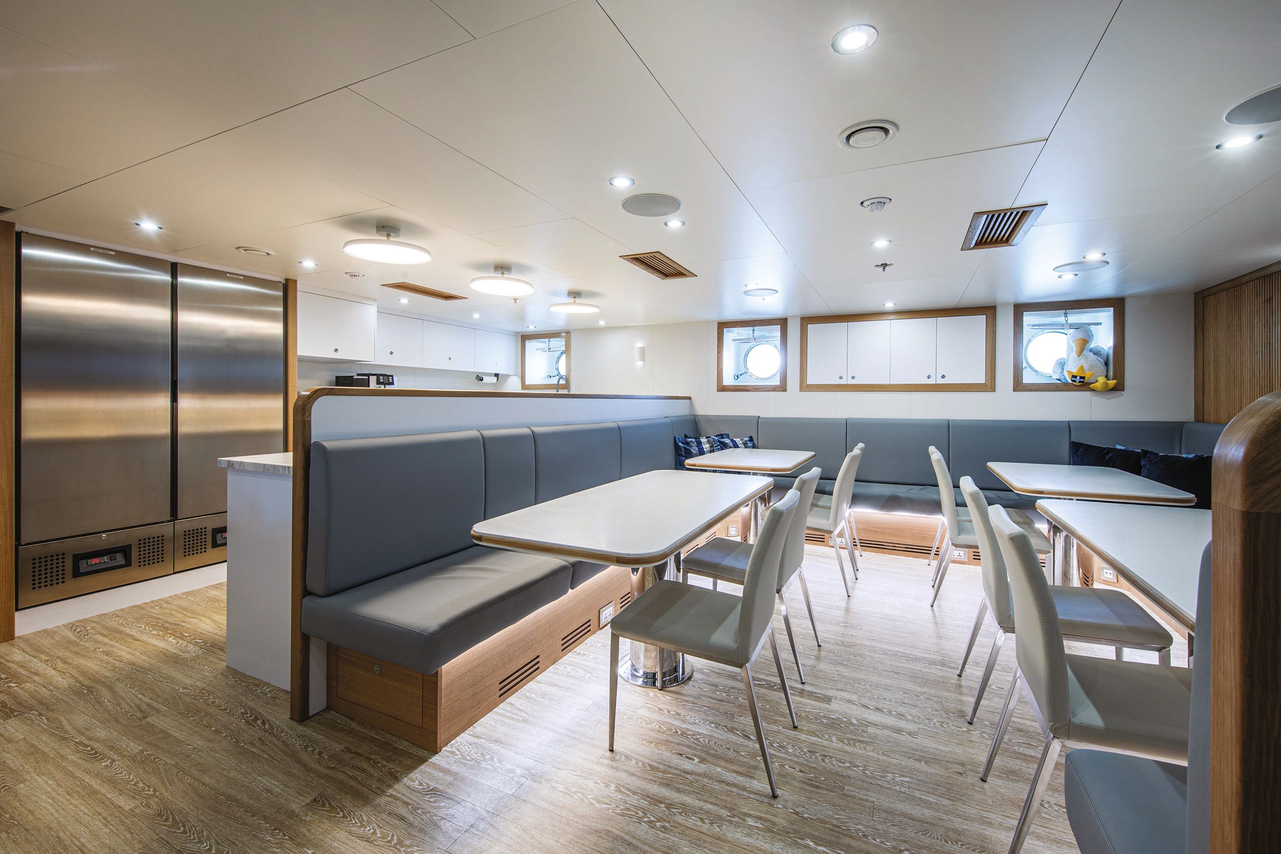 Kitchen area with blue leather banquette seating, dining tables and chairs