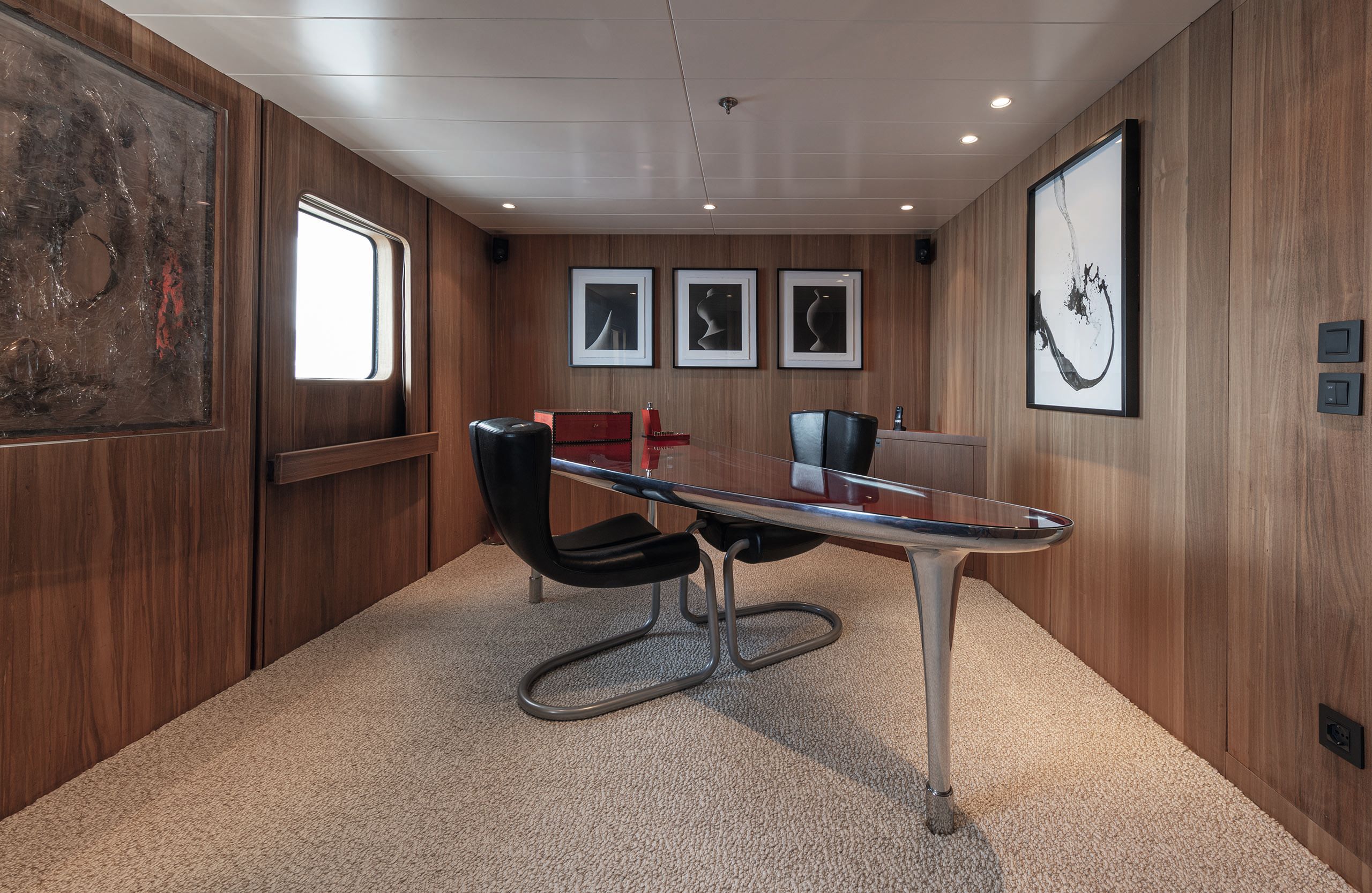 Dark wood panneled office with table and chair in the centre