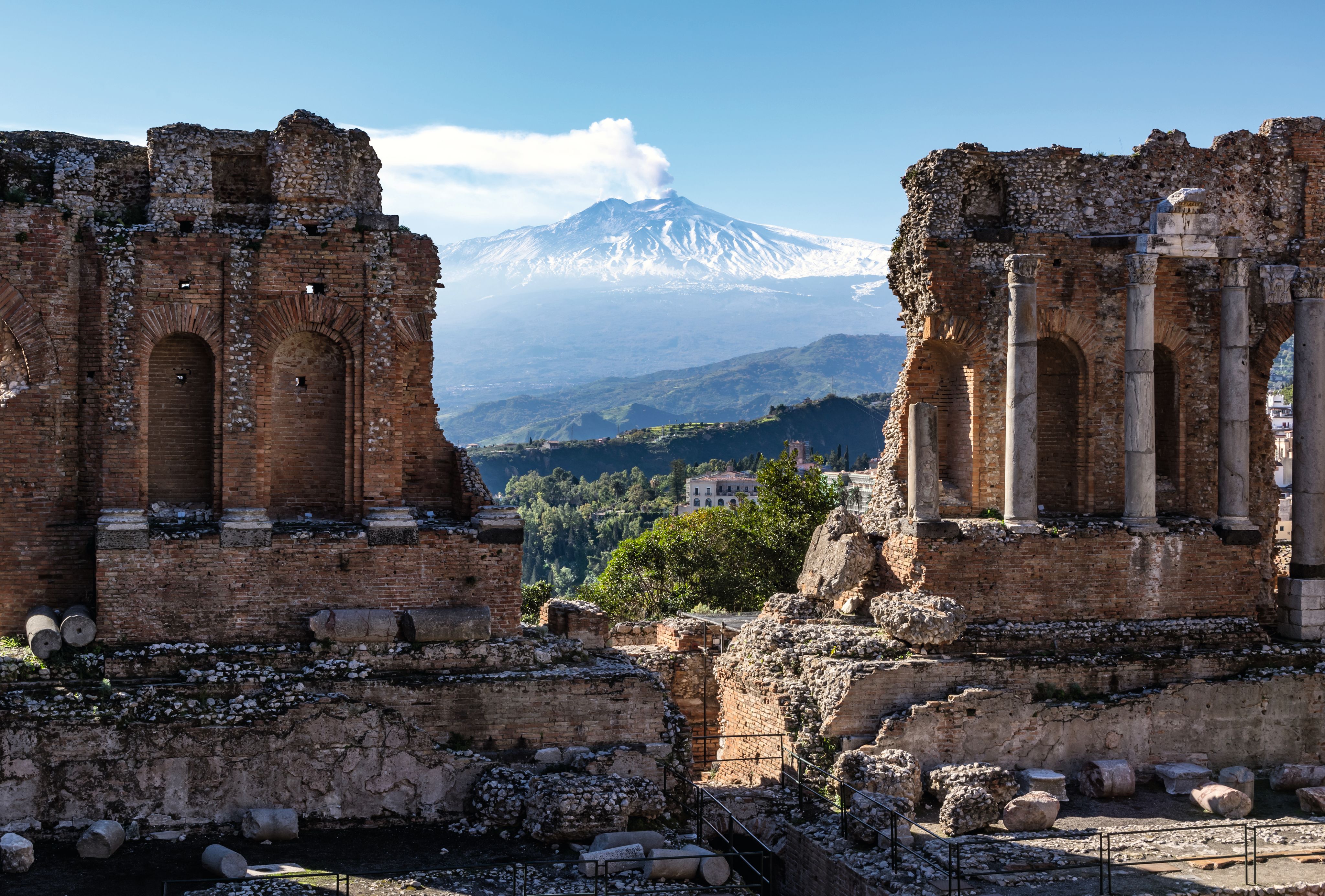 Looking through two ruins in Sicily towards a volcano