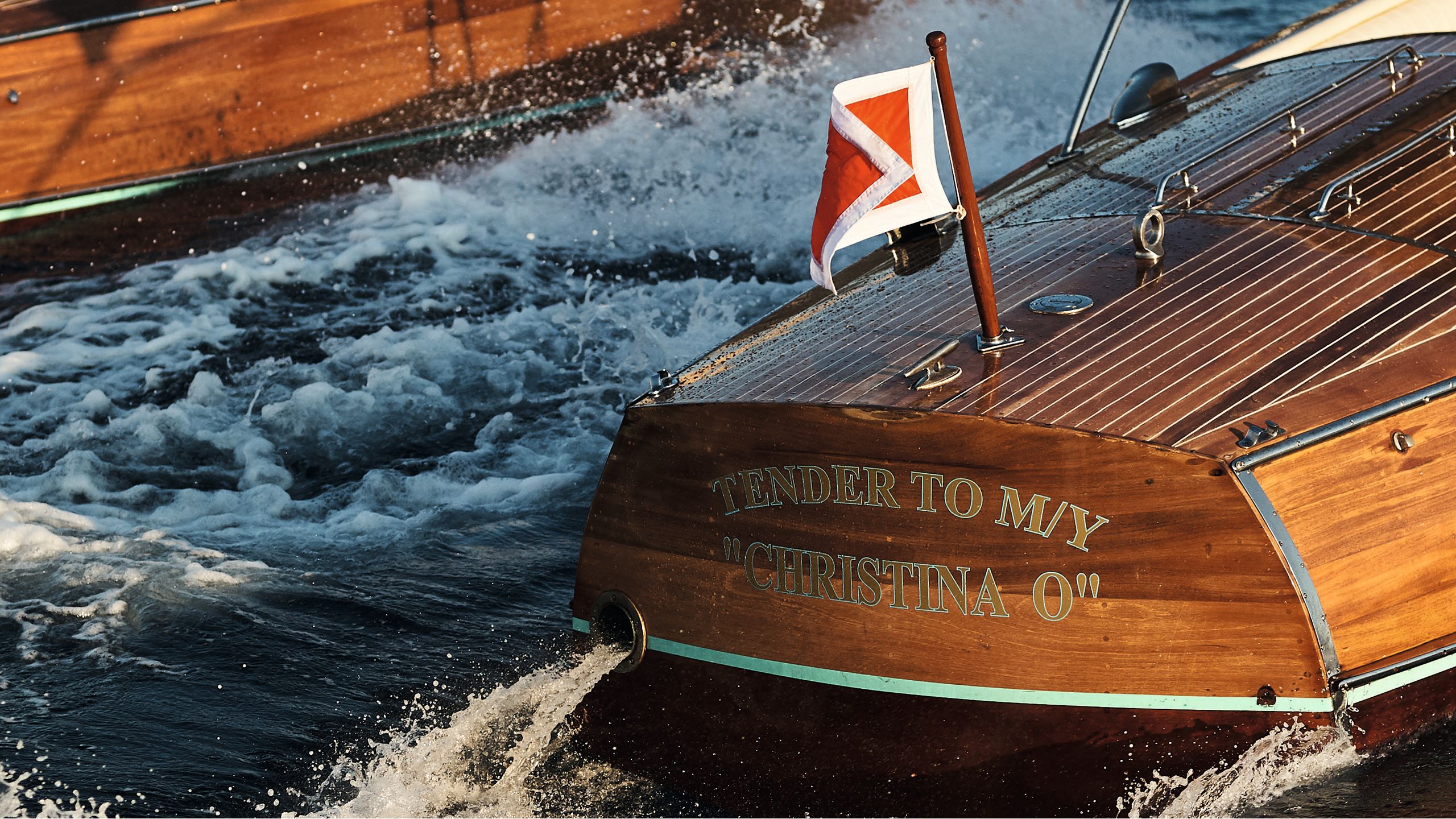 Close-up of the back of one of Christina O's tenders. It is teak coloured and has "tender to my Christina O' written in gold on the back