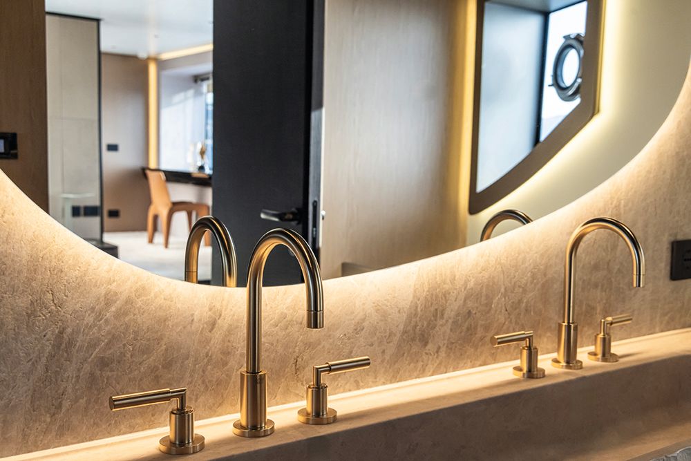 Bathroom mirror and taps with leather-pannelled wall