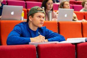 Student tar notater i auditorium på Sonans