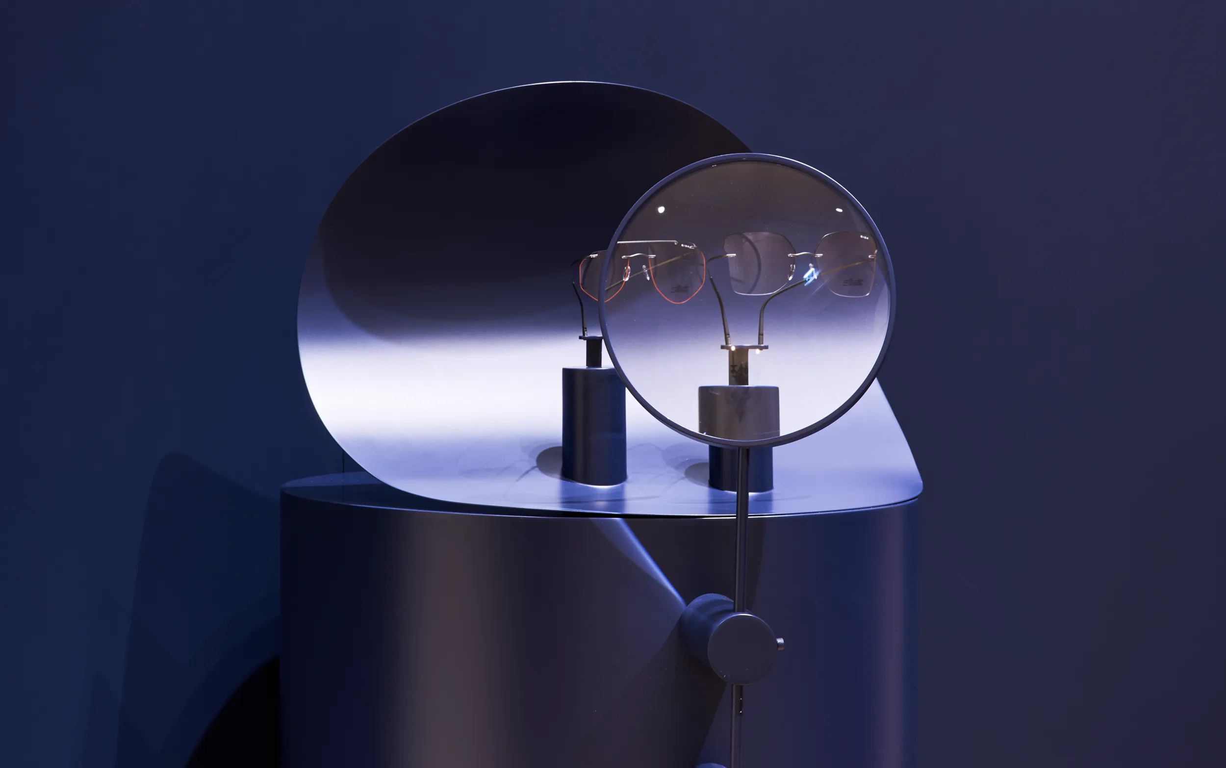 Premium eyewear displayed amidst fluid tubed glass structures within an acoustically optimized retail environment.