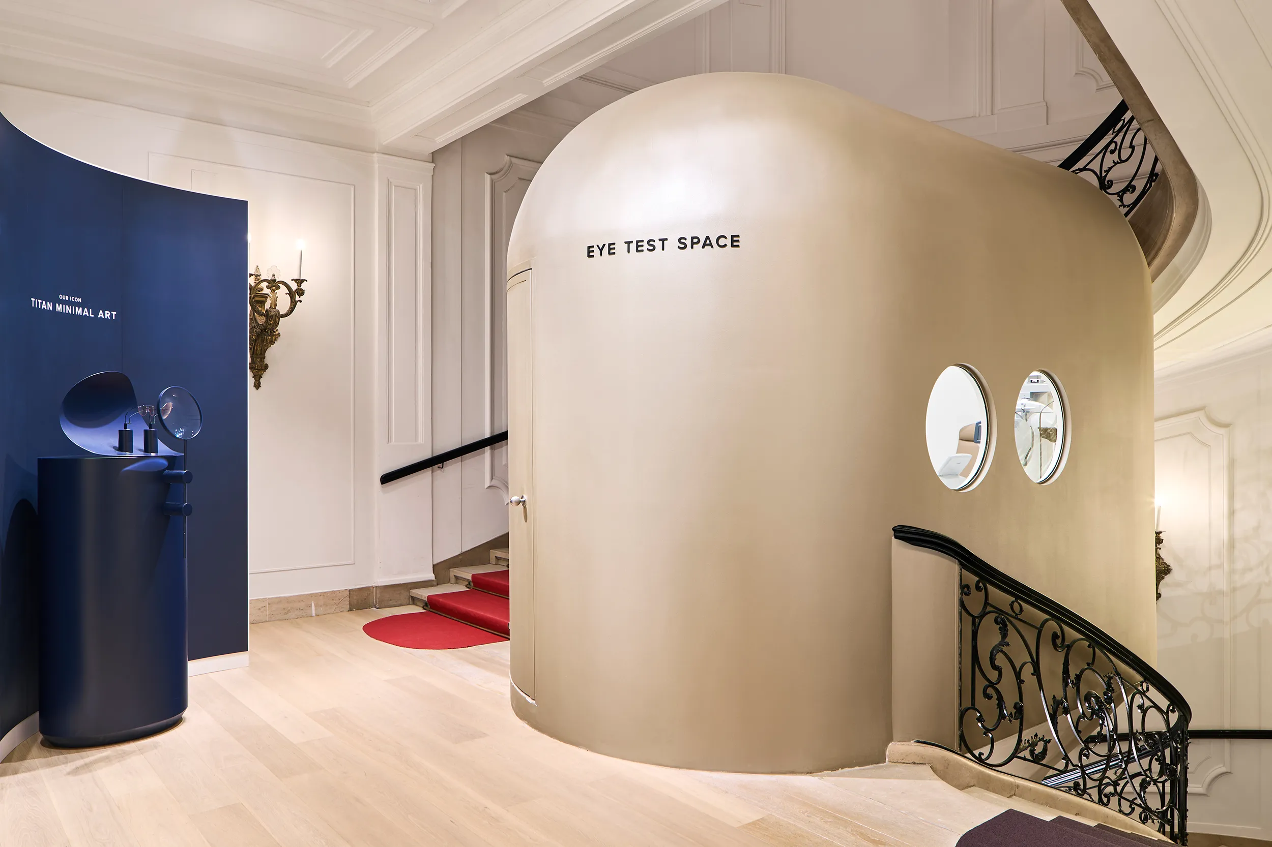 Grand Gründerzeit staircase leading to product presentations and Eye Test Space with discreet wireless audio integration.