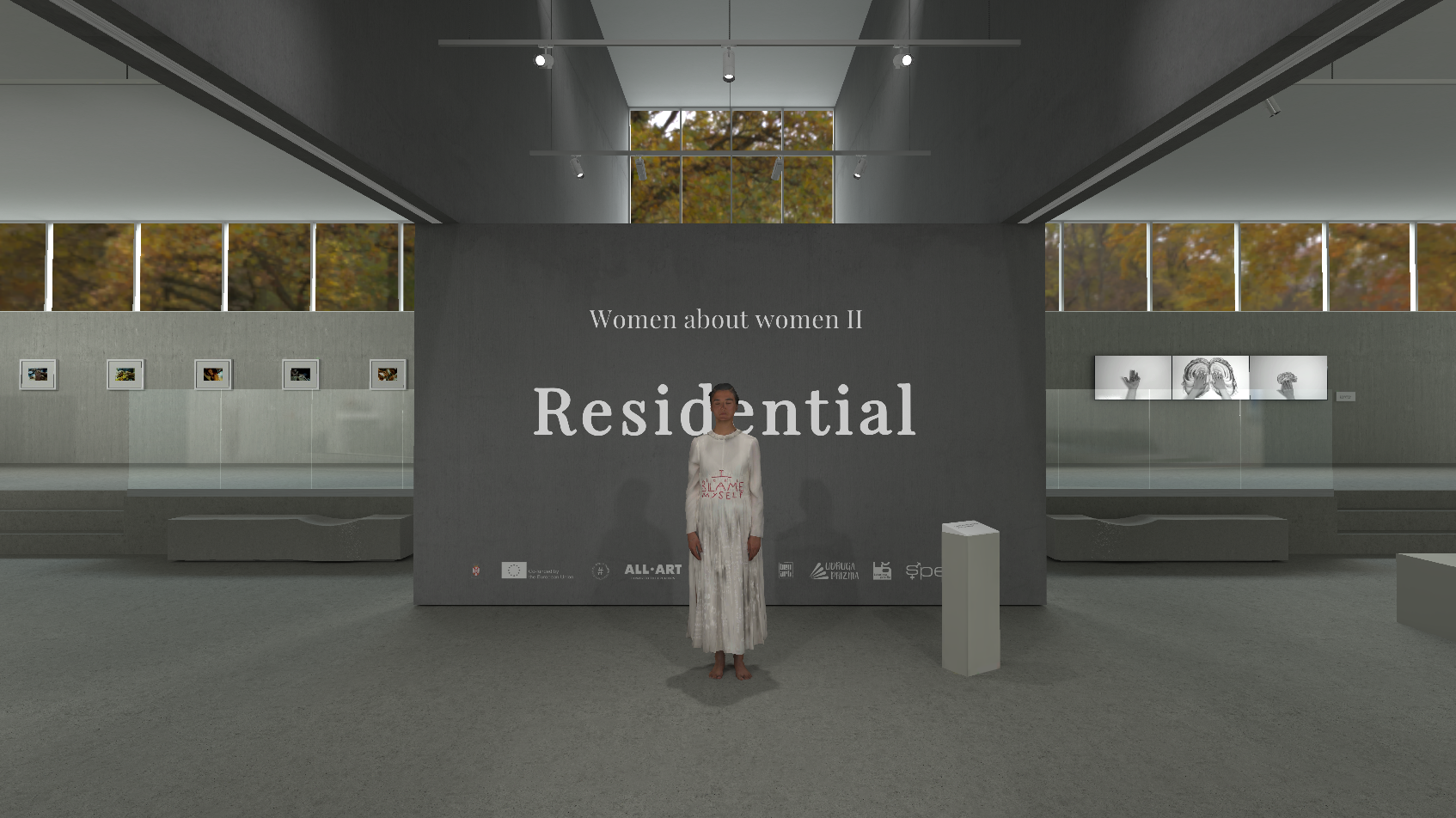 Modern art gallery interior with a 'Women about women II' exhibition. A woman stands in front of a large wall with the title 'Residential'. The gallery has high ceilings with skylights, concrete benches, and is adorned with various framed artworks. Autumn trees are visible through the upper windows.