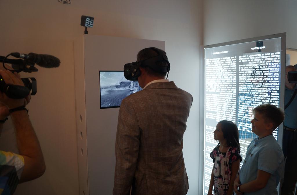 A person wearing a VR headset facing a screen showing a snowy scene.