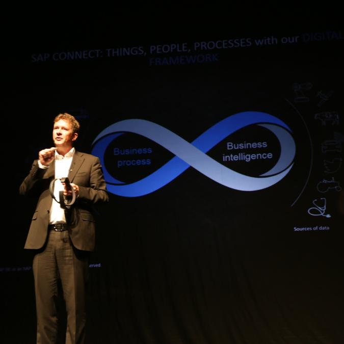 A presenter speaks at the 13th SAP Forum Belgrade 2017 about digital business trends with a visual aid highlighting business process and intelligence.