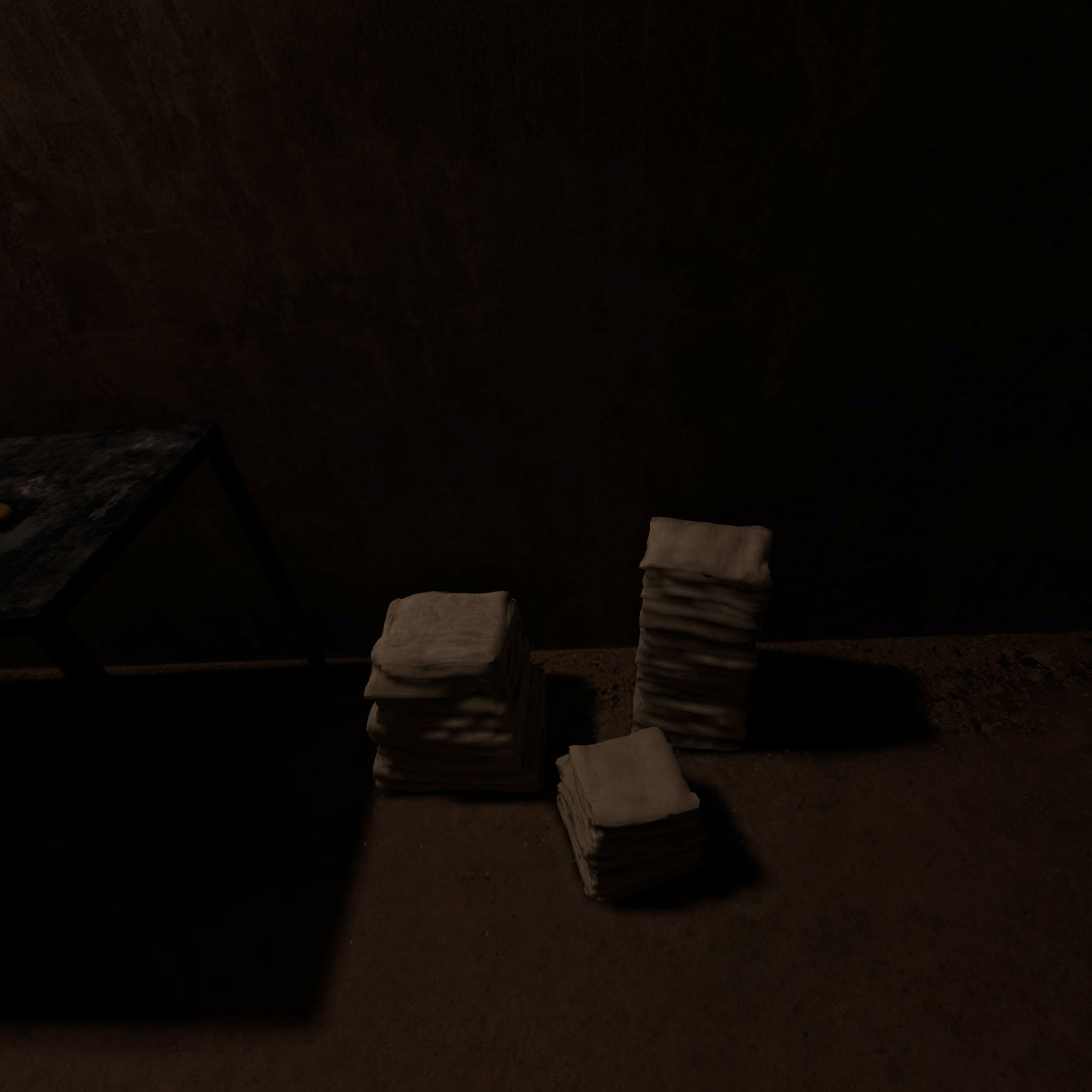 A stack of fabrics sits on the floor in a dimly lit room.