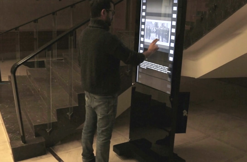 A person stands by an interactive totem at the Museum of Yugoslav History, engaging with the digital display showcasing historical content.