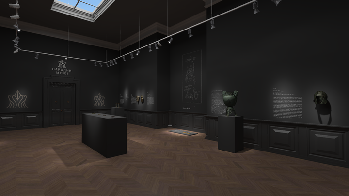 Dimly lit museum exhibit space with a skylight, showing informational panels on black walls and several pedestals with artifacts, including a bronze cauldron and a helmet.
