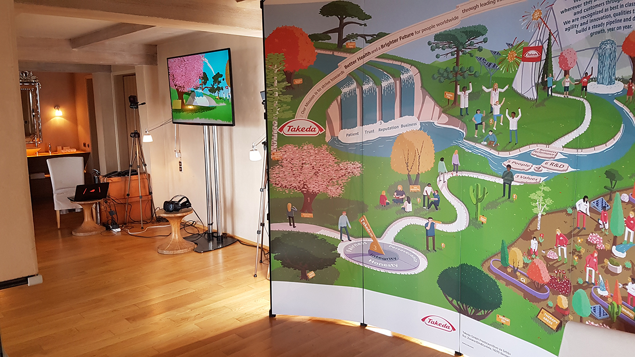 A well-lit room displaying the Takeda Vision 2025 VR Experience, with VR equipment on the left and a vibrant, illustrated banner on the right detailing Takeda’s roadmap to better health and a brighter future, emphasizing patient trust, reputation, and business.