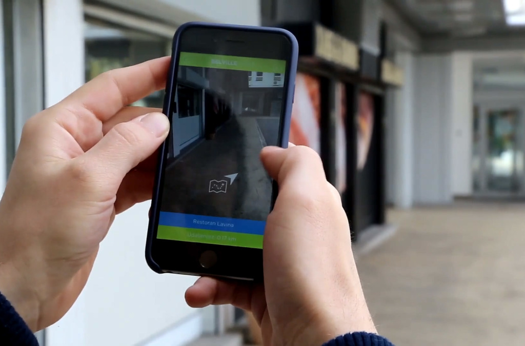 User holding a smartphone with the Belville Smart App opened.