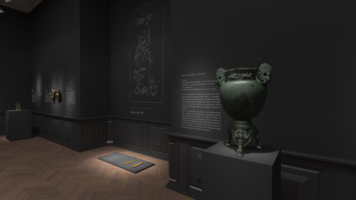 Gallery corner with dark walls and herringbone wood floor, displaying a large green bronze vessel on a stand and wall texts with illustrations of archaeological finds.