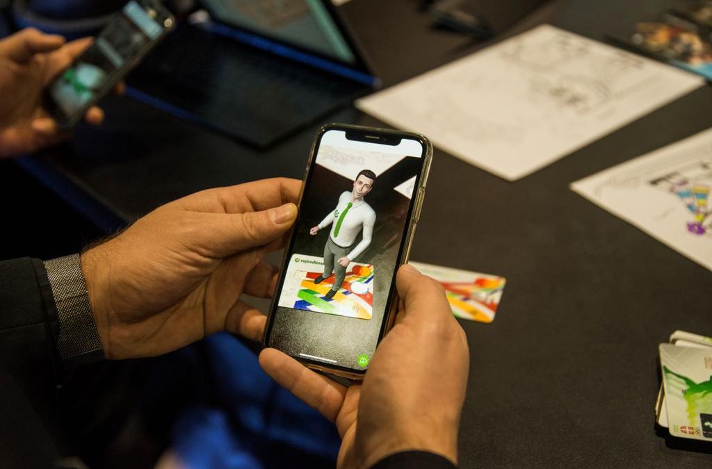 Close-up of a smartphone screen held by a user, where Voban, the virtual assistant from Vojvođanska bank, appears in augmented reality on the bank's card.
