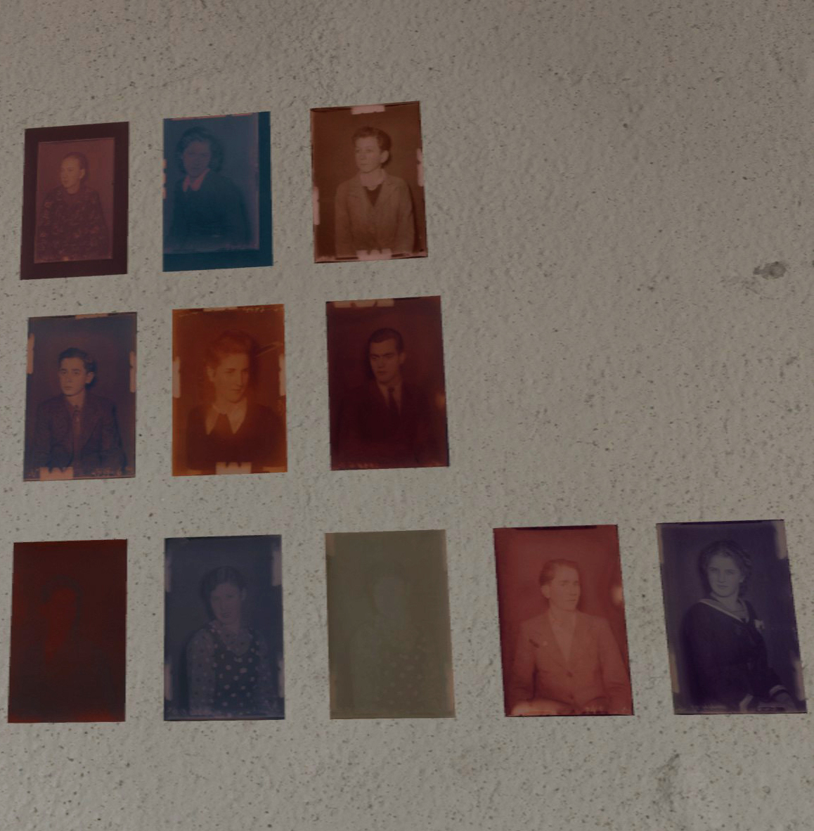 A detail from Mia Cuk's VR art exhibition displaying an array of vintage portraits in different sizes and hues, mounted on a white wall, each telling its own story from various eras.
