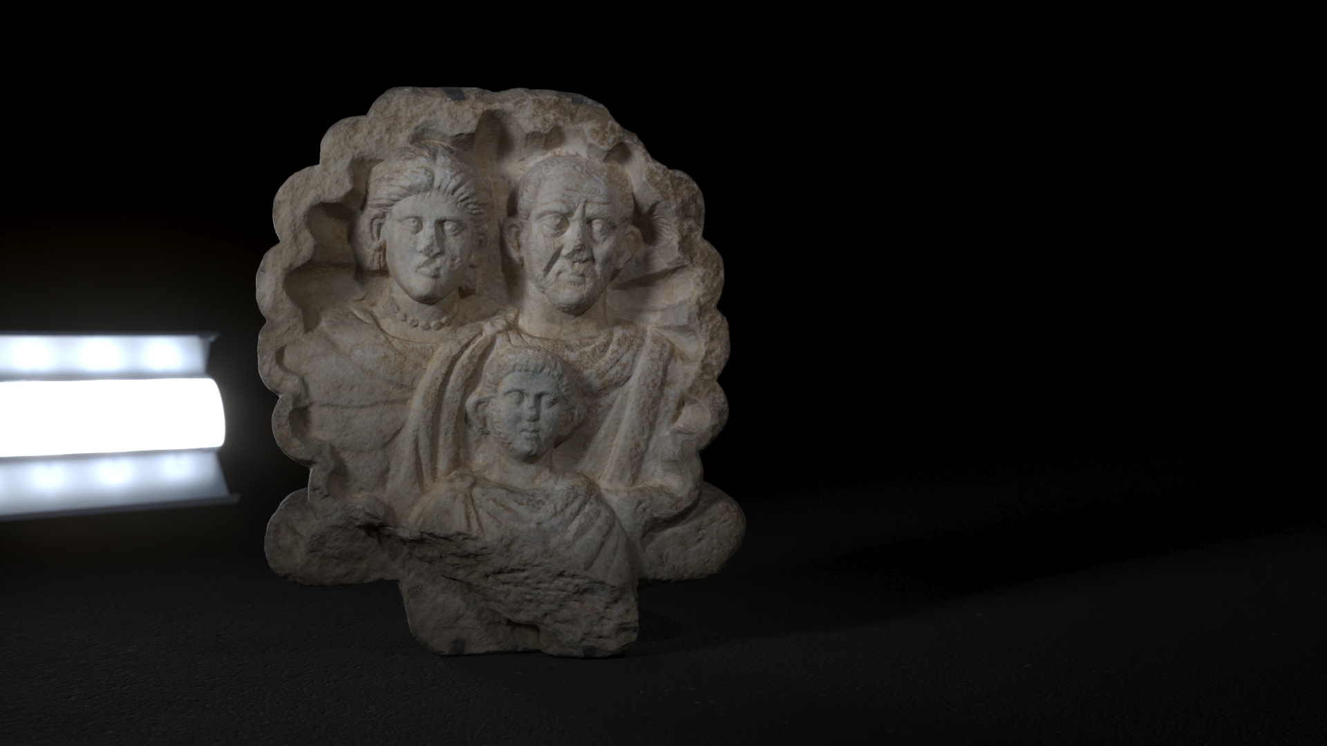 A Roman-era relief sculpture of three figures, possibly representing a family with two adults and a child, carved in stone. It is well-lit from the left, casting deep shadows, and set against a dark background.