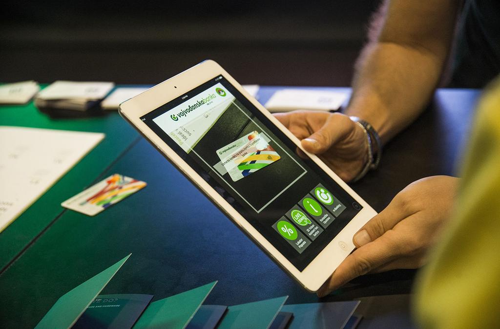 Voban, the virtual assistant, is shown on an iPad screen providing banking assistance and information services, with the interface showing multiple functional options.