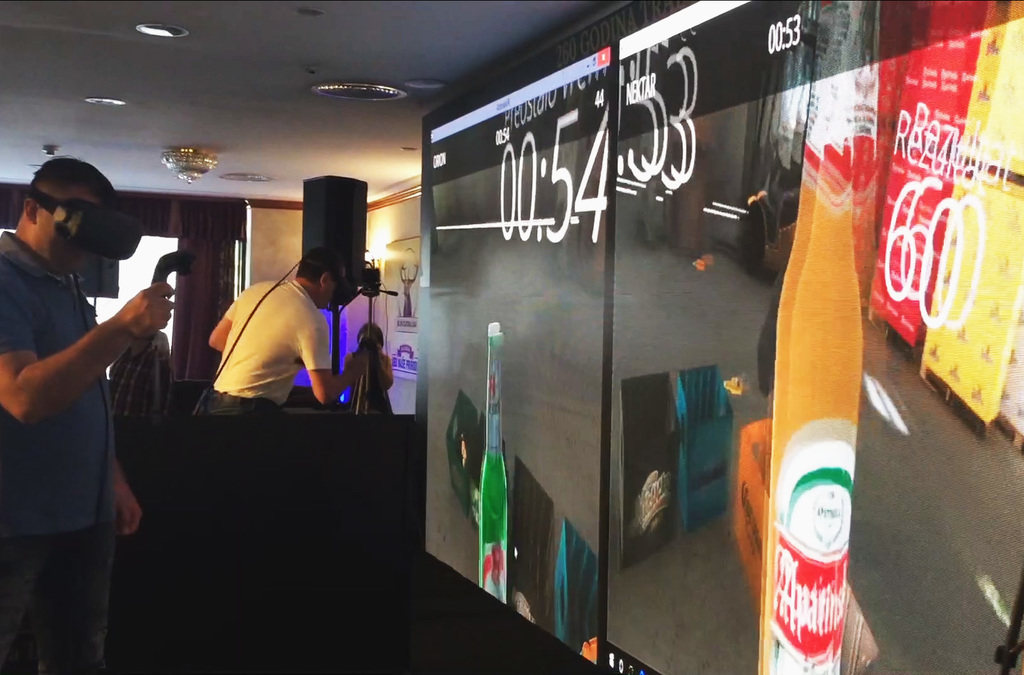 A lively VR party atmosphere with a player actively engaged in a virtual reality game, sorting beer bottles while spectators watch on a giant screen setup.