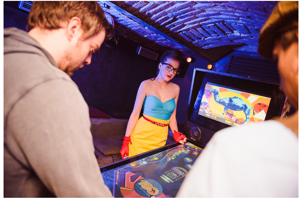 A man plays a Camel-themed digital pinball game at a brand event.