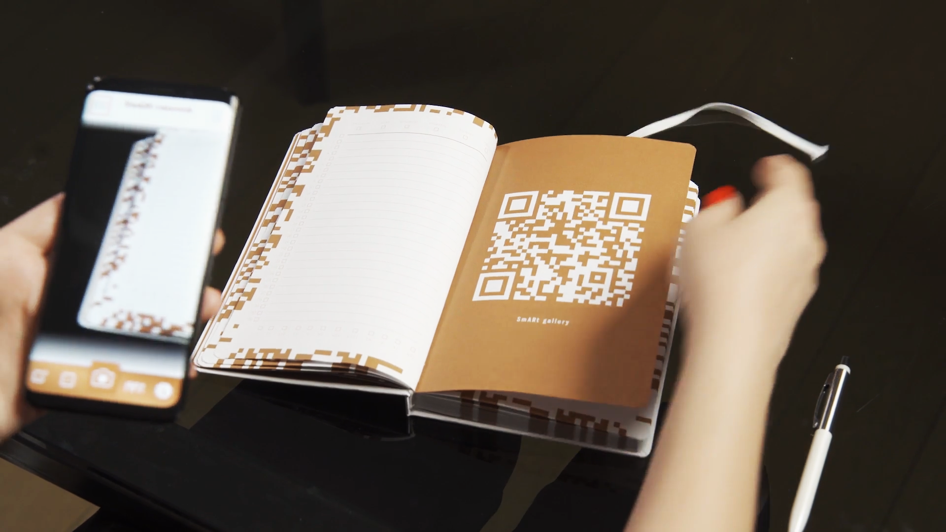 A user's hand holds a smartphone with the SmARt AR app, capturing a QR code on an open Banca Intesa planner to convert written content into a digital entry.