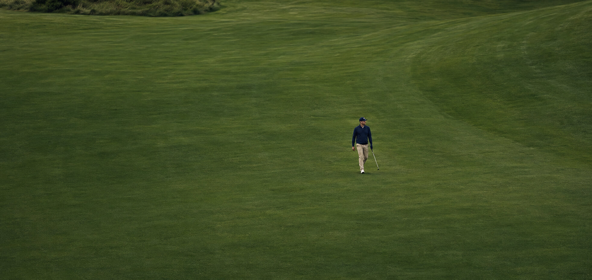 Golfspelare klädd i funktionella golfkläder ute på golfbanan