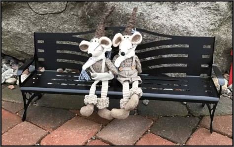 Trädgårdsdekoration i form av en svart miniatyr-parkbänk i metall.