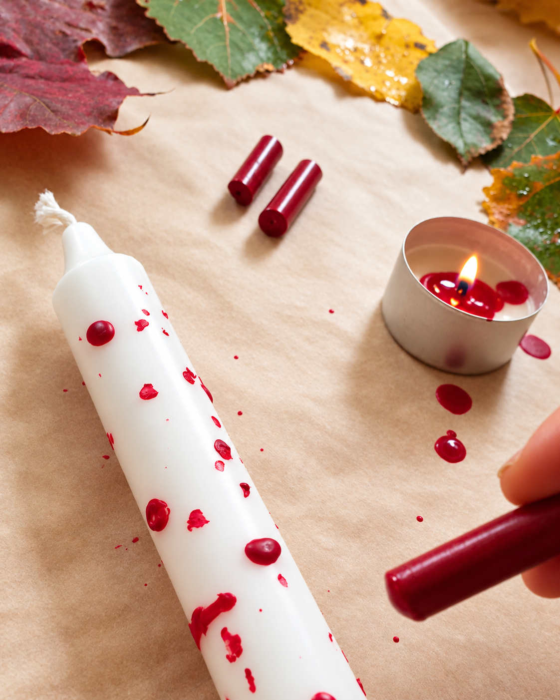 Dekorera vita ljus till halloween med smält röd vaxkrita