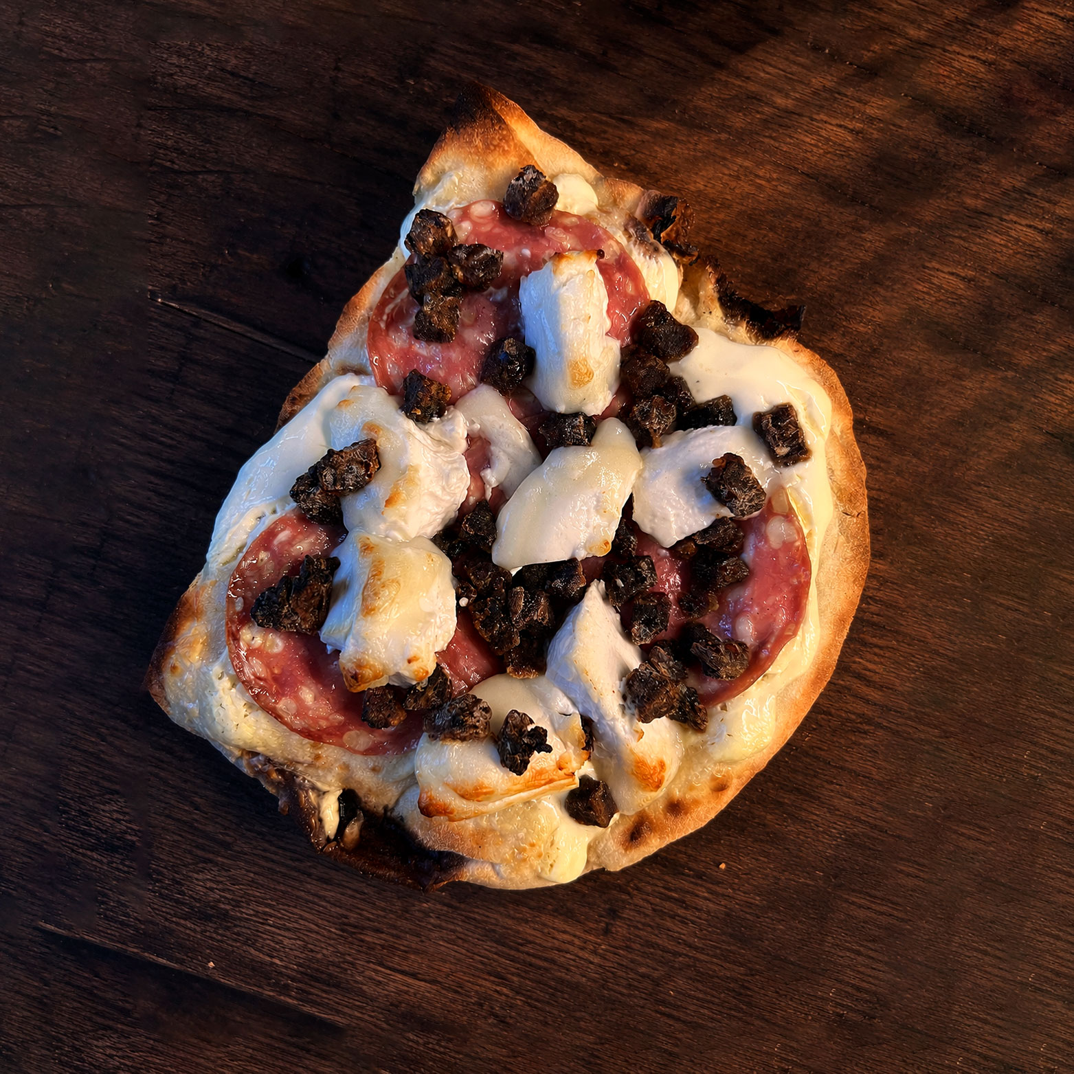 Krispig pinsa med chèvre, salami, dadlar och parmesan