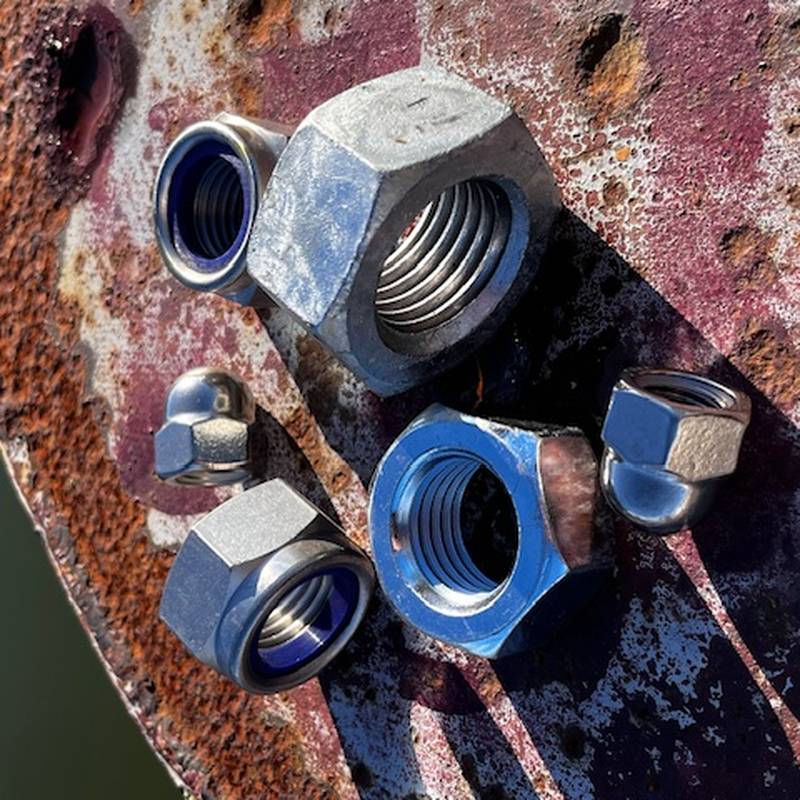 Rostfria och förzinkade muttrar på rostig yta – A4, FZB och FZV