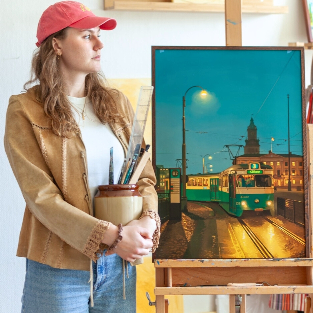 Elin Östberg i ateljén med målning av Göteborgs spårvagn