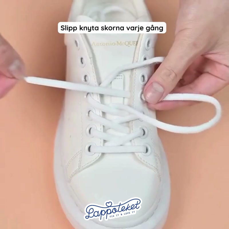 Vita elastiska skosnören med cylinderlås i en sneaker