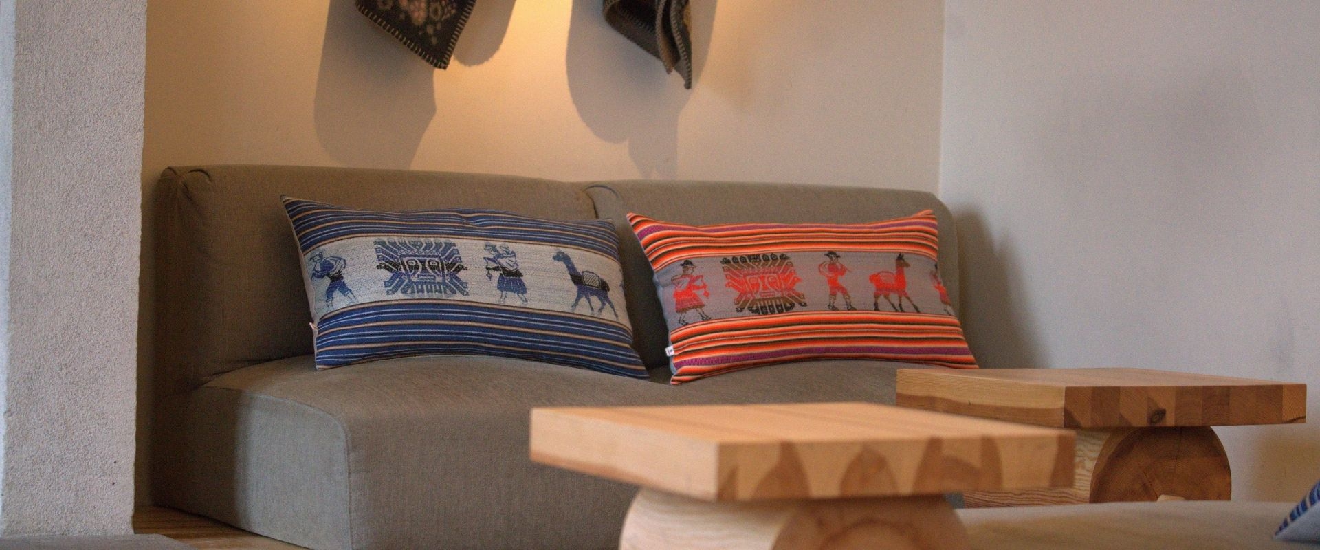 Soffa med två kuddfodral i traditionellt aguayotyg från Alpawayo i en varm och stilren restaurangmiljö.