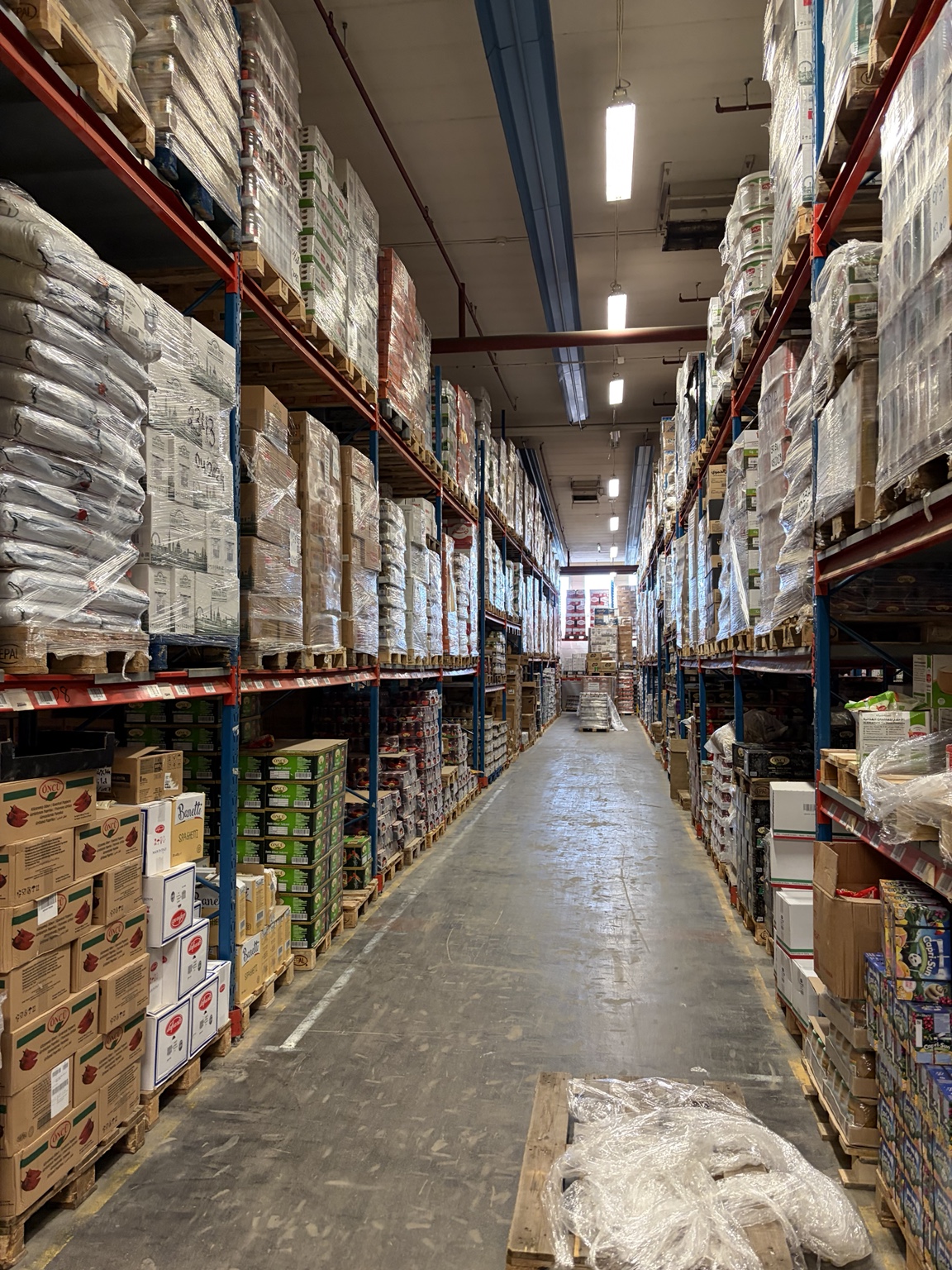 Livsmedelslager med pallställ och inplastade pallar