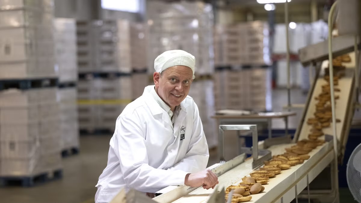 Medarbetare vid en produktionslinje för bakverk